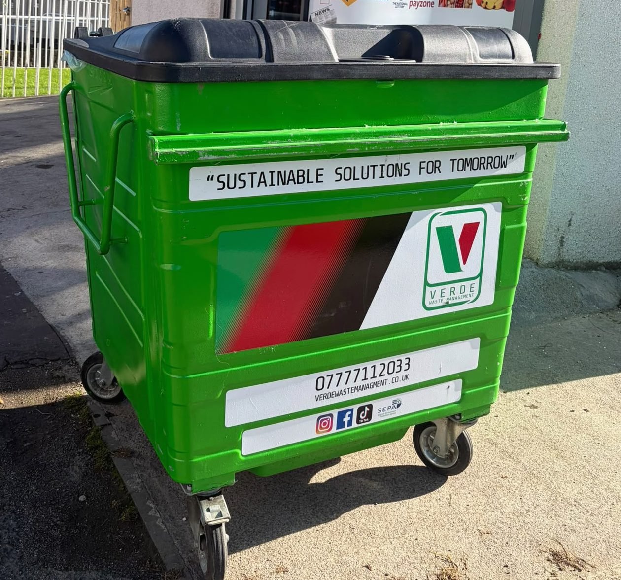 A green Verde Waste Management 1100 litre bin